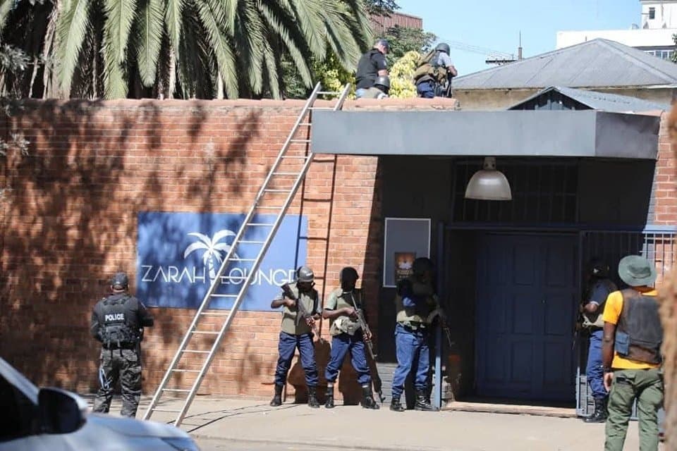 Armed police officers position themselves at the entrance of Zarah Lounge during Saturday's hostage situation in Bulawayo.