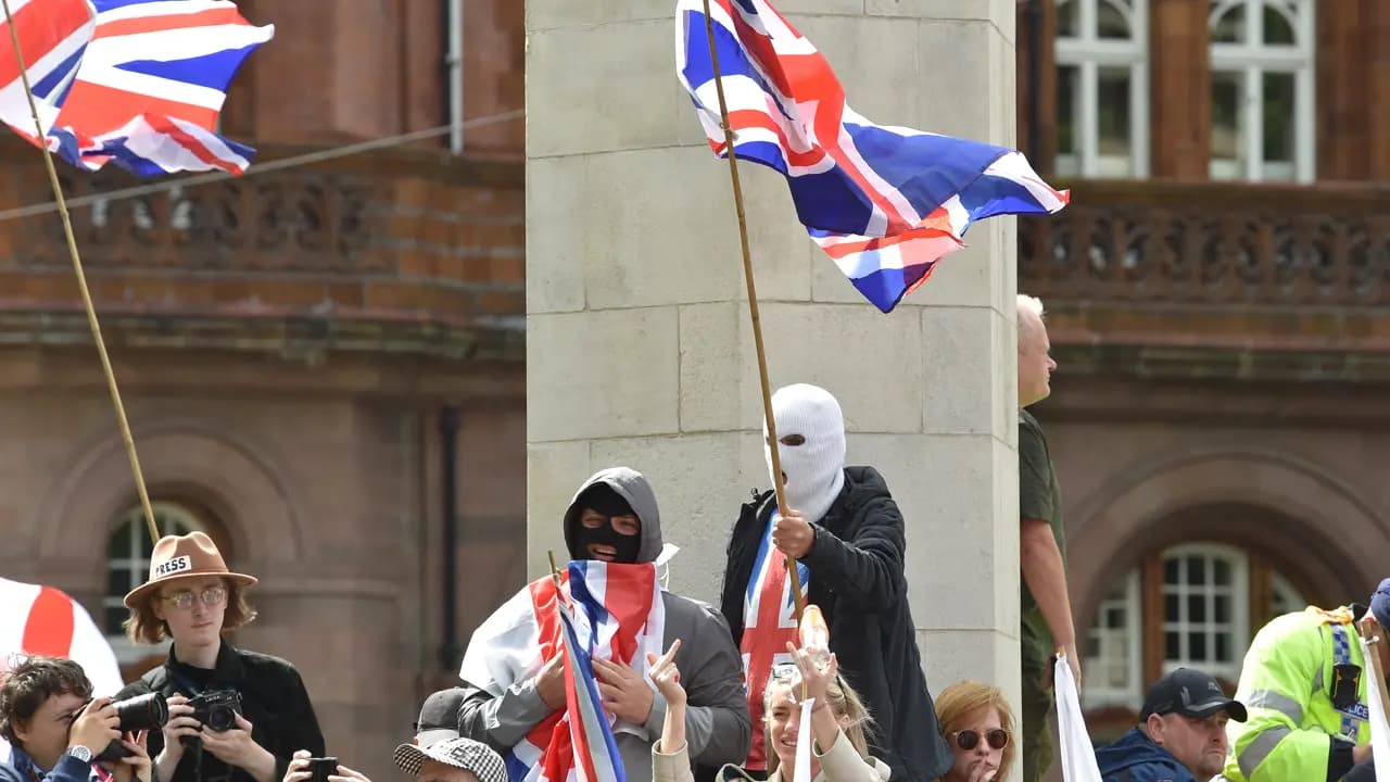 Masked supporters join a Britain First party March for Remigration calling for mass deportation in Manchester northwest England on August 2 2025