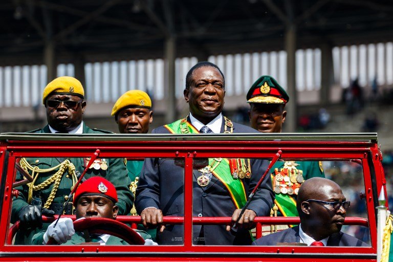 Report Focus News Zimbabwe | Report Focus News's President Emmerson Mnangagwa (C) inspects the guard of honour from a car during the Defence Forces Day celebrations held at the National Sports Stadium in Harare on August 14, 2018. / AFP PHOTO / Jekesai NJIKIZANA